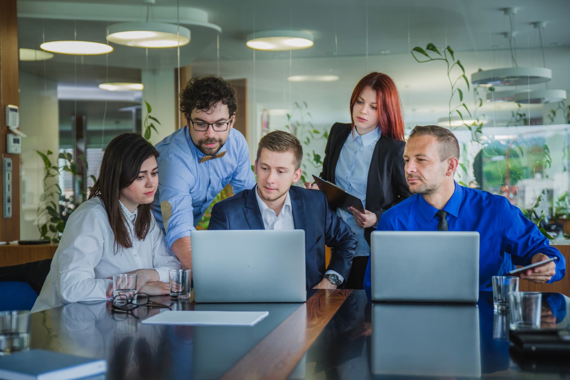 Operations specialists reviewing work together around a laptop